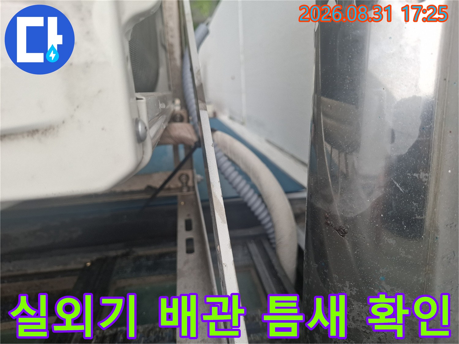 에어컨 실외기 배관이 통과하는 벽면의 틈새를 근접 촬영한 모습입니다.