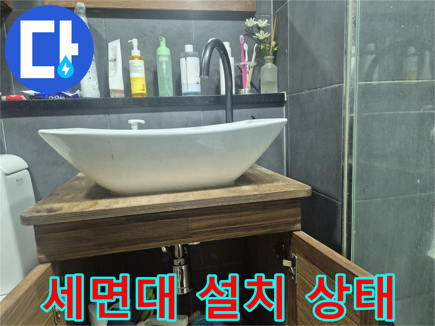 나무 선반과 세면대가 설치된 화장실 내부 전경