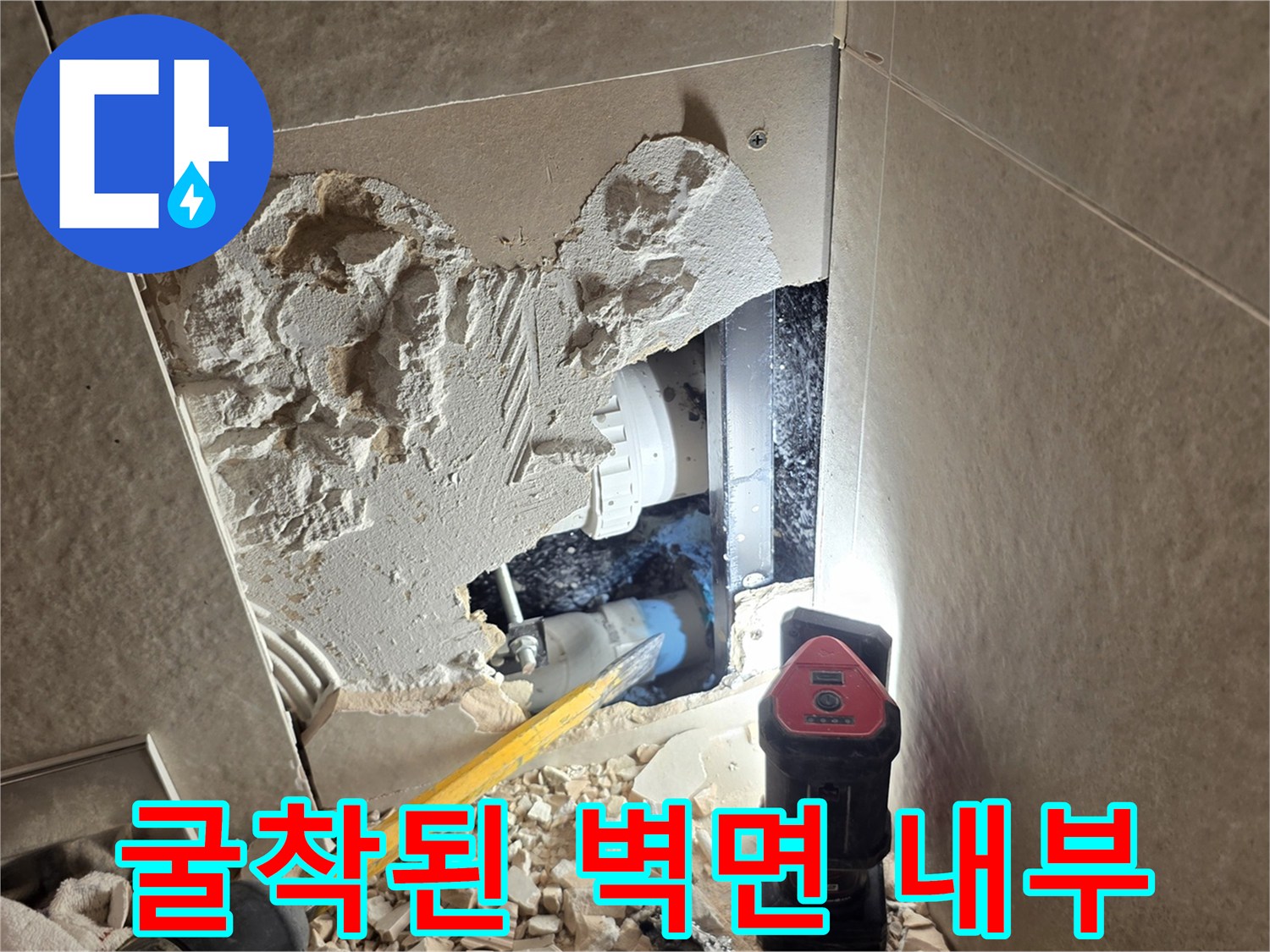 벽면 굴착을 통해 노출된 파손된 배관과 작업 장비