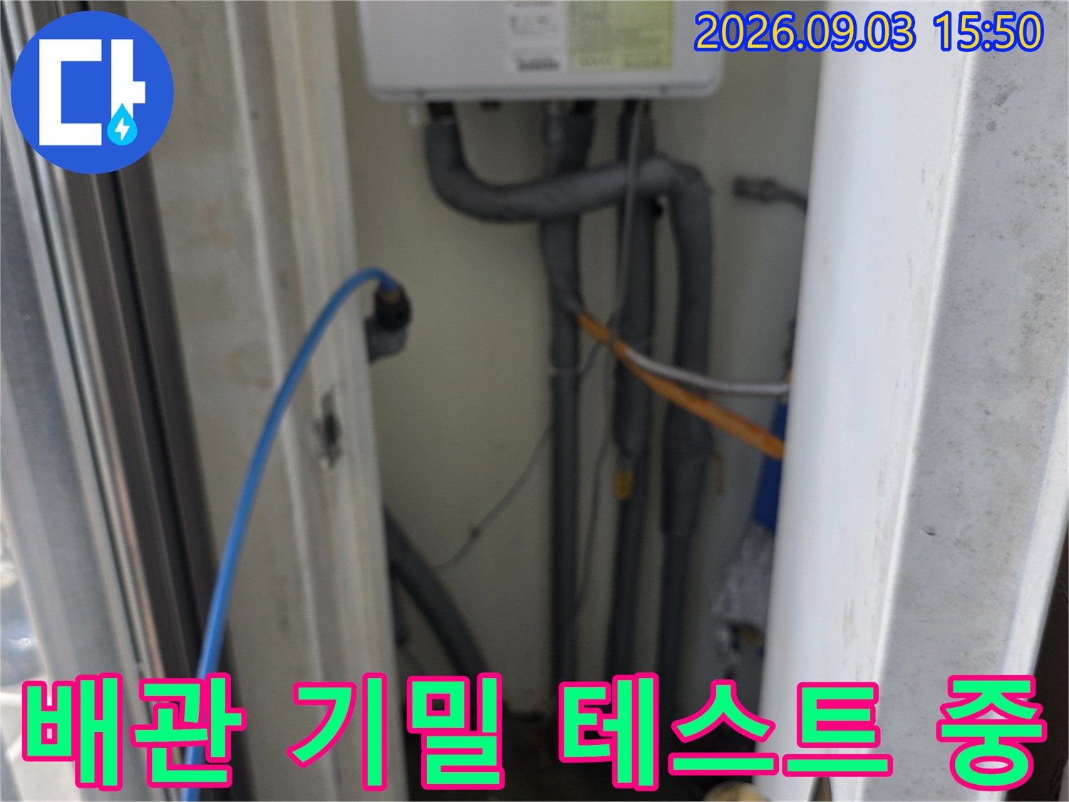 복잡하게 얽힌 외부 배관과 압력 검사용 파란색 호스 연결부