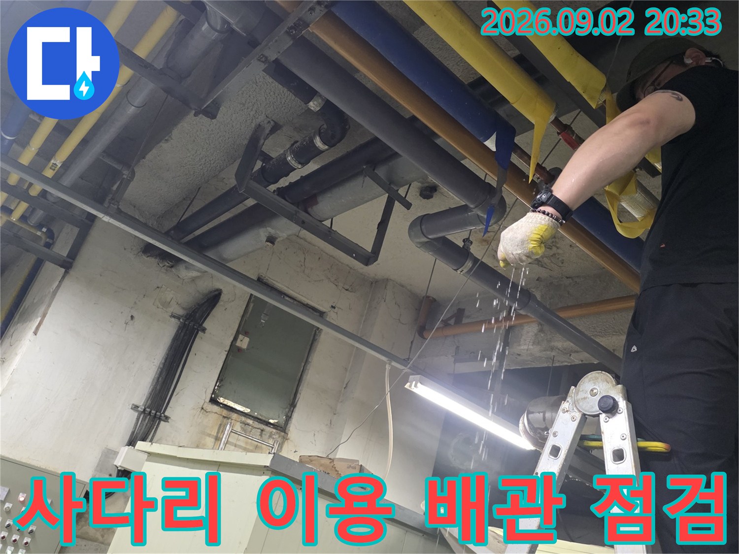 사다리를 타고 올라가서-노란색과 파란색 보온재로 감싸진 배관을 점검하는 모습