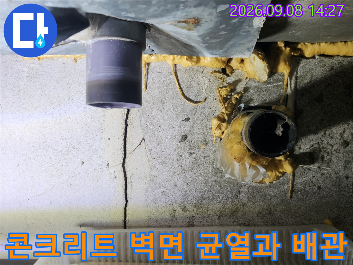 배수관 주변의 콘크리트 균열과 습기로 인한 오염 부위 상세 촬영