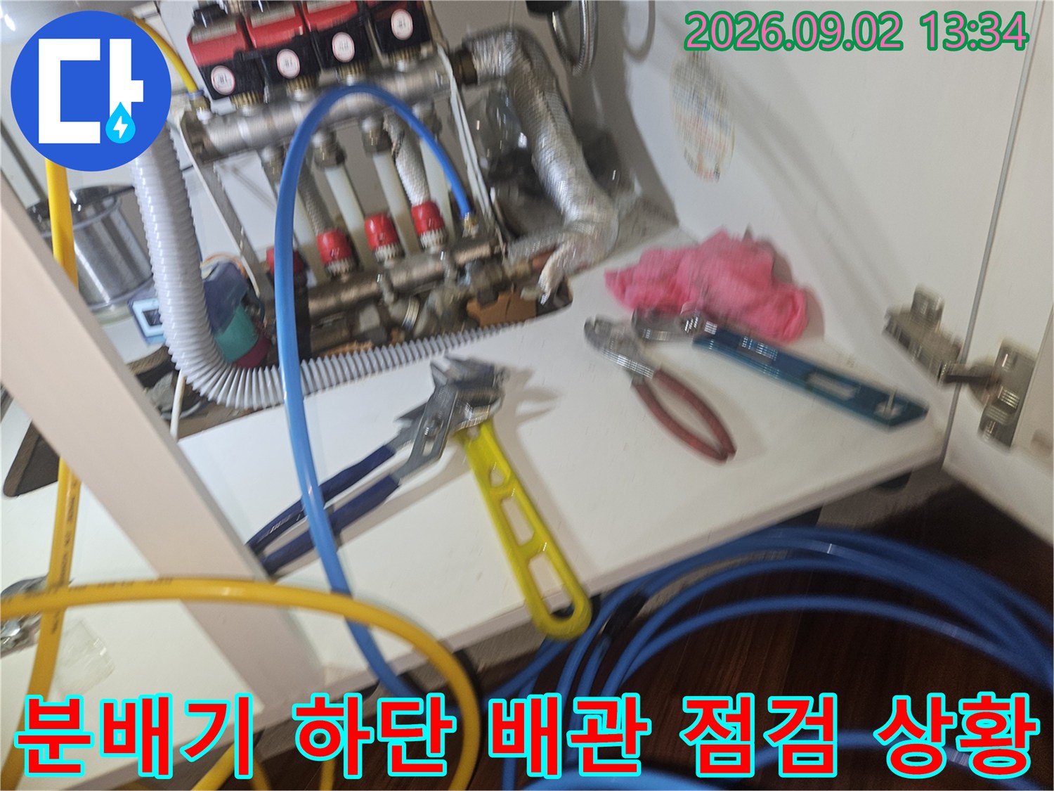 보일러 분배기와 연결된 호스 및 점검용 몽키스패너