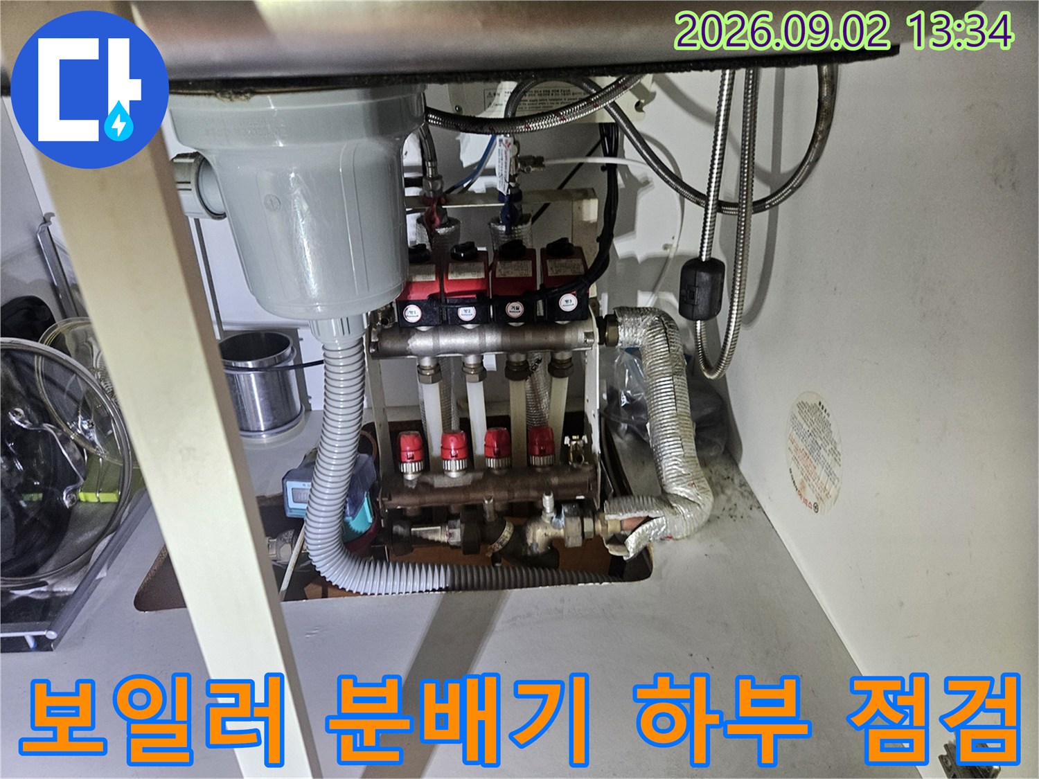 싱크대 아래 배관들이 모여 있는 분배기 부위의 근접 촬영 사진입니다.
