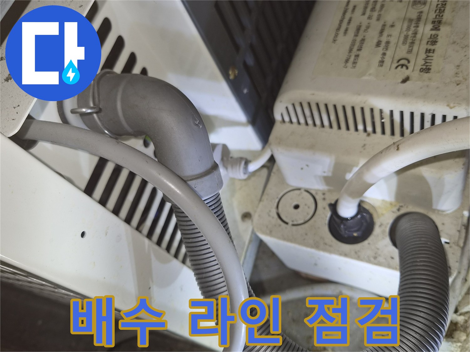 기계 장치와 연결된 굵은 주름관 형태의 배수 호스