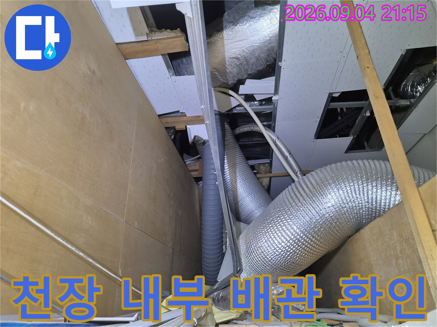 은박 단열재로 된 덕트와 에어컨 배수 배관이 지나가는 상가 천장 점검구 내부 모습입니다.