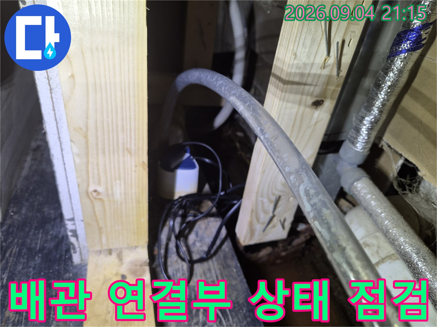 천장 내부 배관-목재 구조물과 배수관 근접 사진