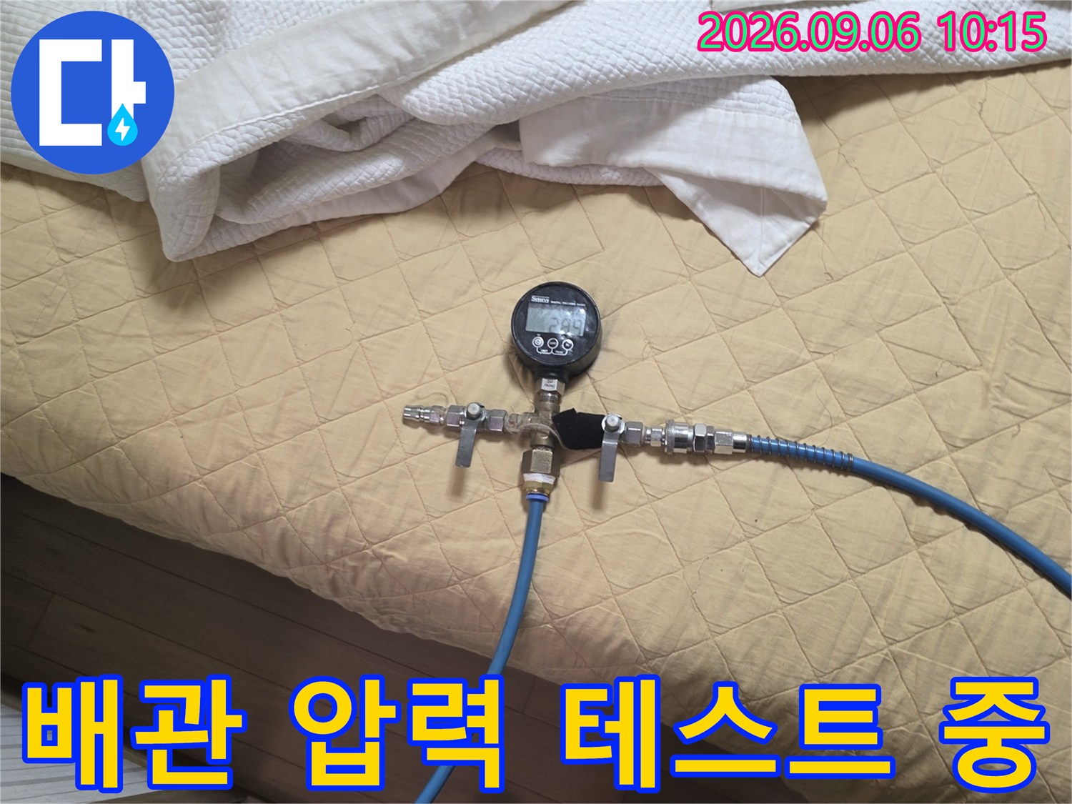 파란색 호스와 압력계가 연결된 배관 점검 모습
