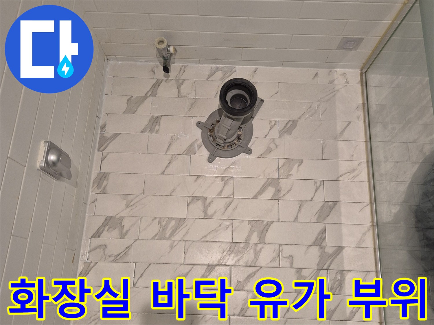 하얀색 패턴 타일과 금속 배수구 입구 사진