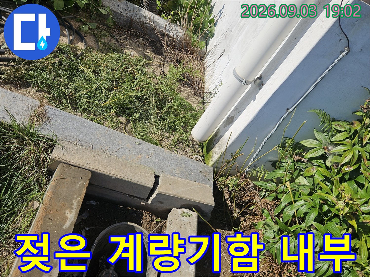습기가 가득한 수도 계량기함-배관 주변의 젖은 흙과 부속 상태를 보여줌