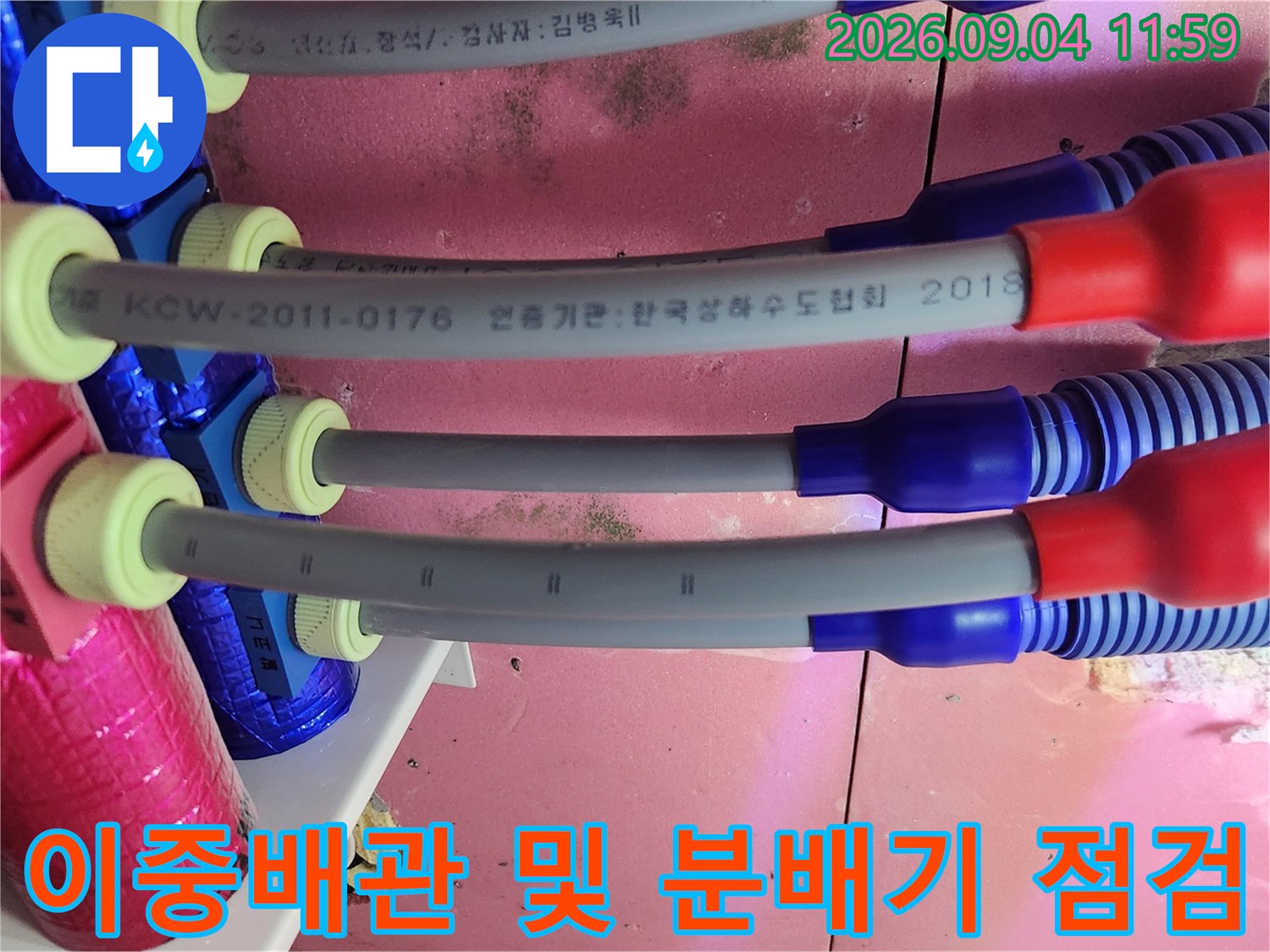 분홍색 보온재와 파란색 이중배관이 연결된 분배기 내부 모습