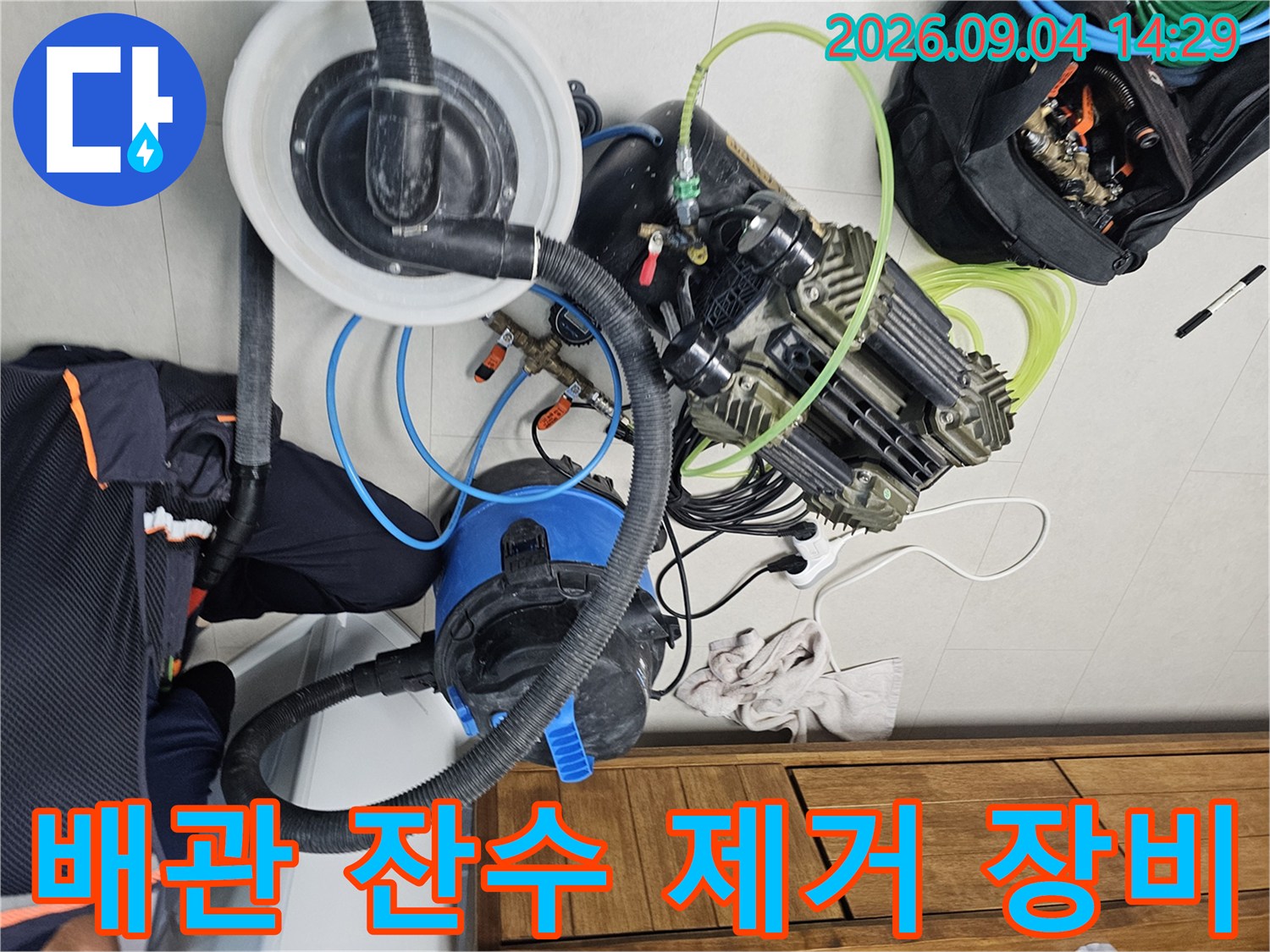 배관 내부의 고인 물을 뽑아내기 위해 현장에 배치된 흡입 장비와 공압 테스트 장치입니다.