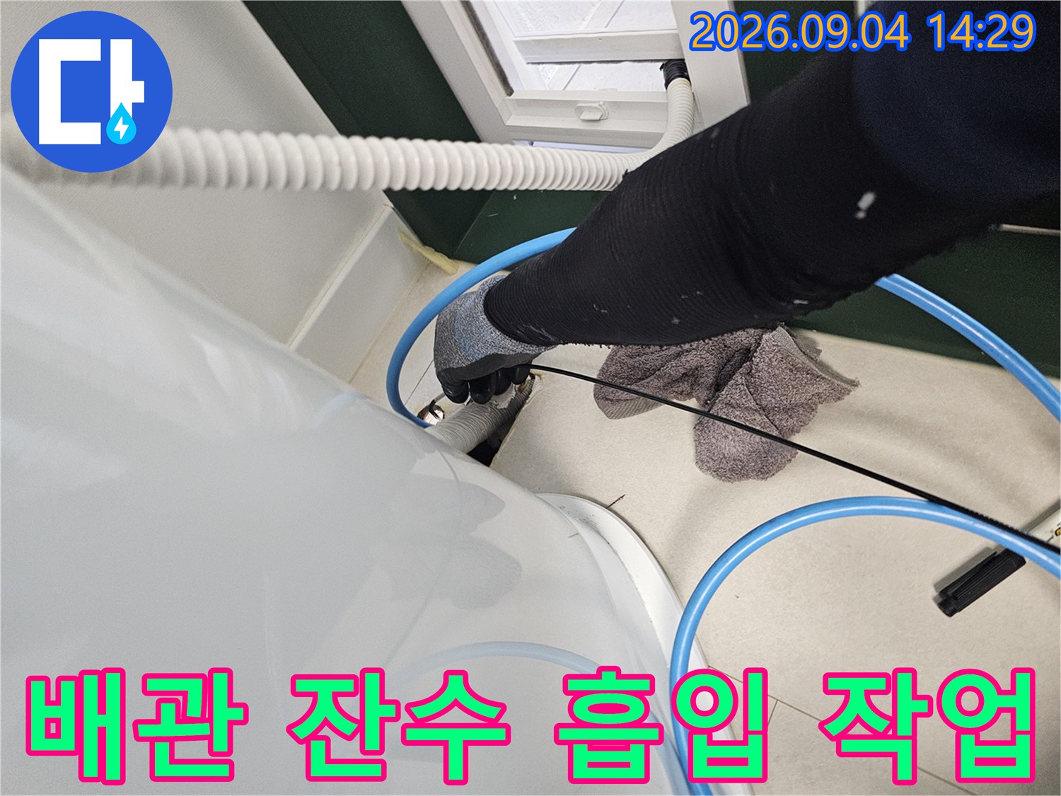 하얀색 배관 장비와 파란색 호스를 이용한 배관 내부 청소 과정