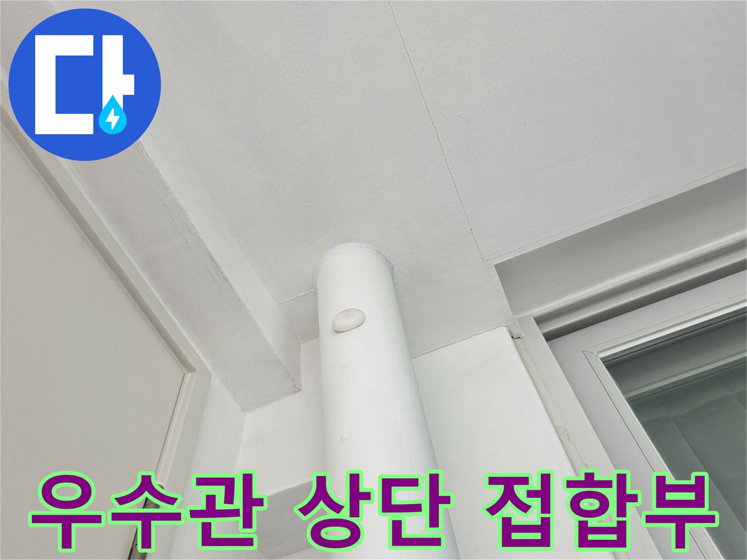 배수관과 천장 마감재가 만나는 지점의 근접 사진입니다.