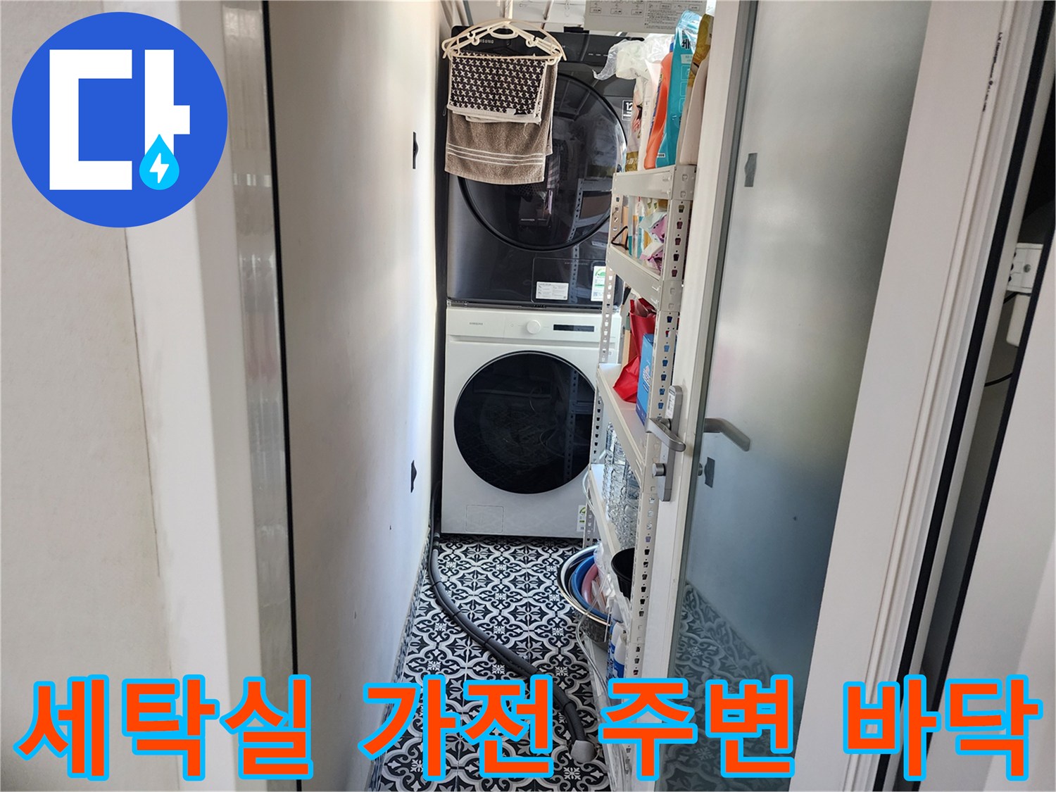 세탁기와 건조기가 설치된 세탁실 내부의 타일 바닥 모습입니다.