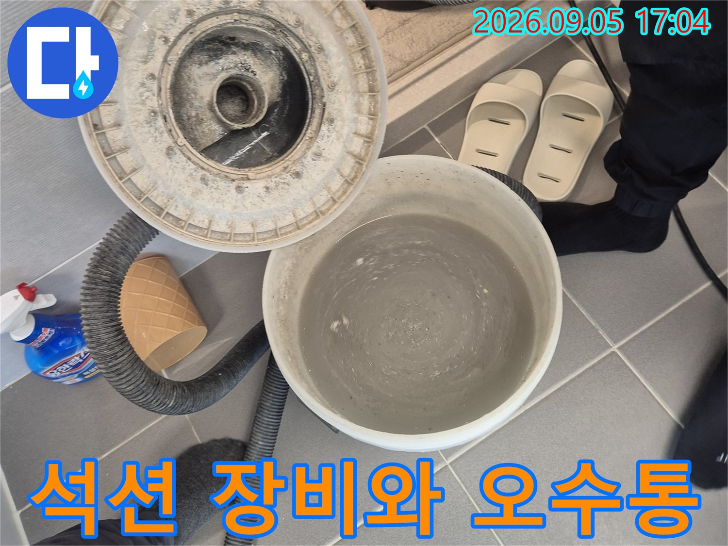 욕조 배관 수리를 위해 사용 중인 석션기와 오수 수거 통