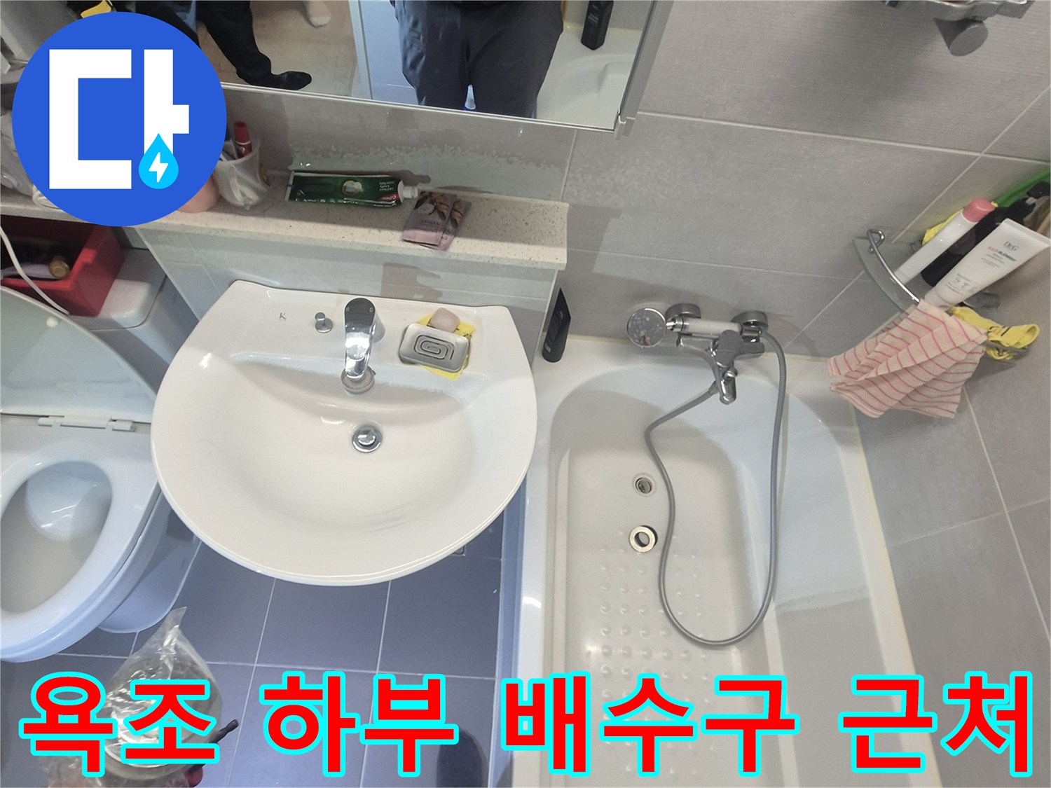 욕조 수전과 배수구가 연결된 화장실 내부 전경