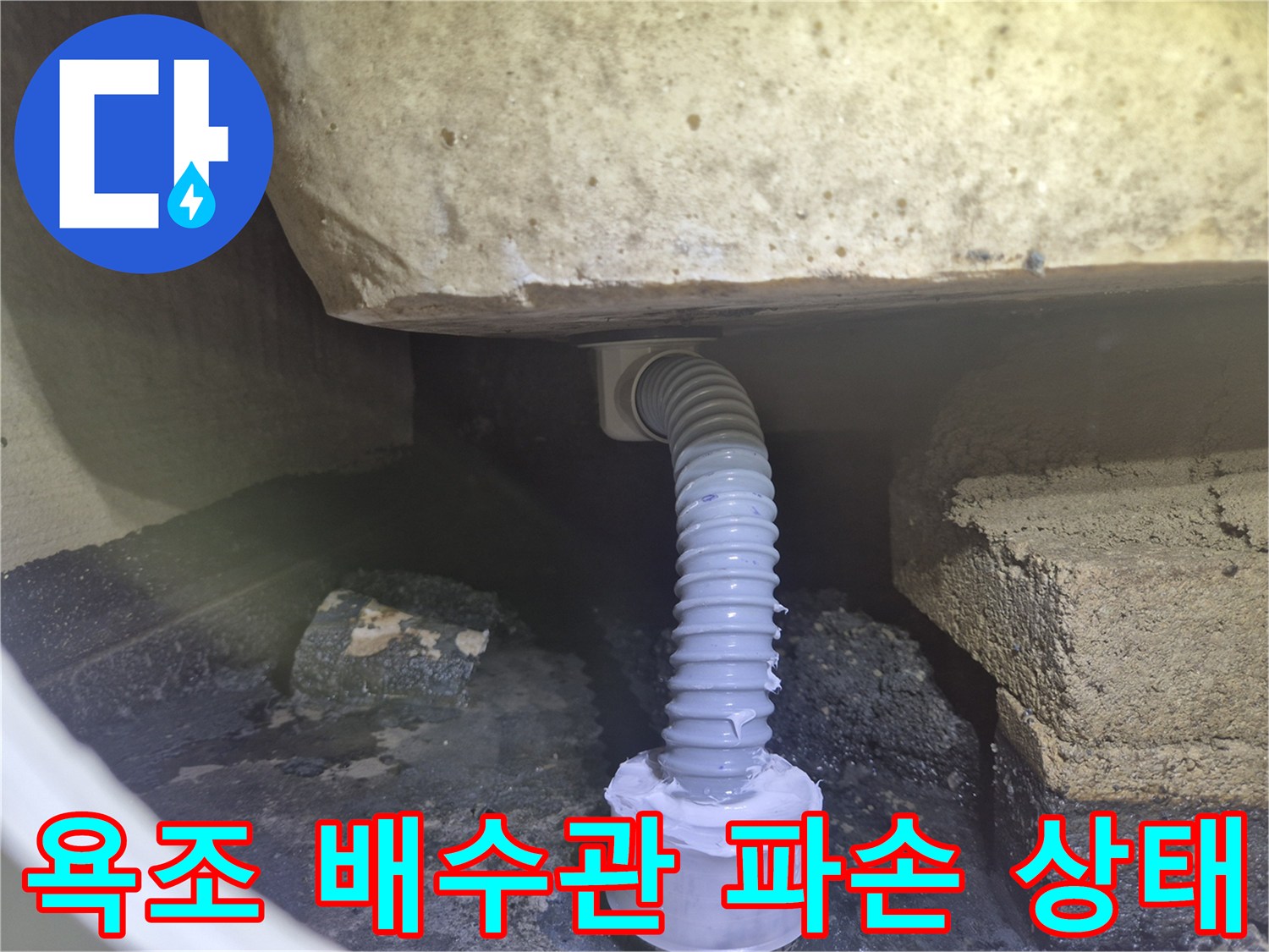 욕조 하부 공간에 보이는 파손된 주름 배관과 연결 부위