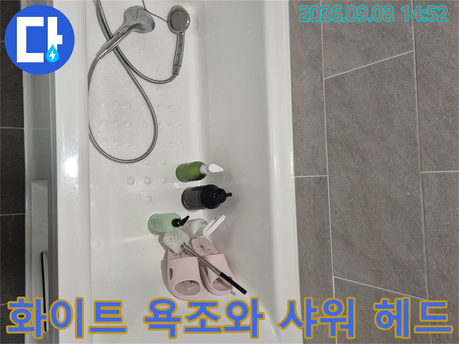 샤워 헤드와 호스가 연결된 화이트 컬러의 욕조 내부 사진입니다.