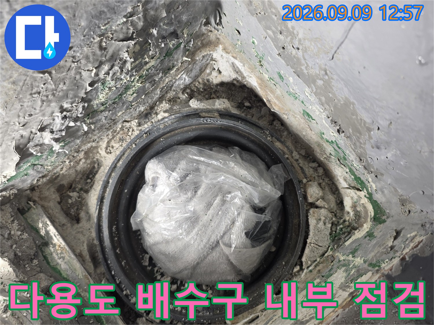 다용도실 배수구 주변의 노출된 배관과 마감재 상태