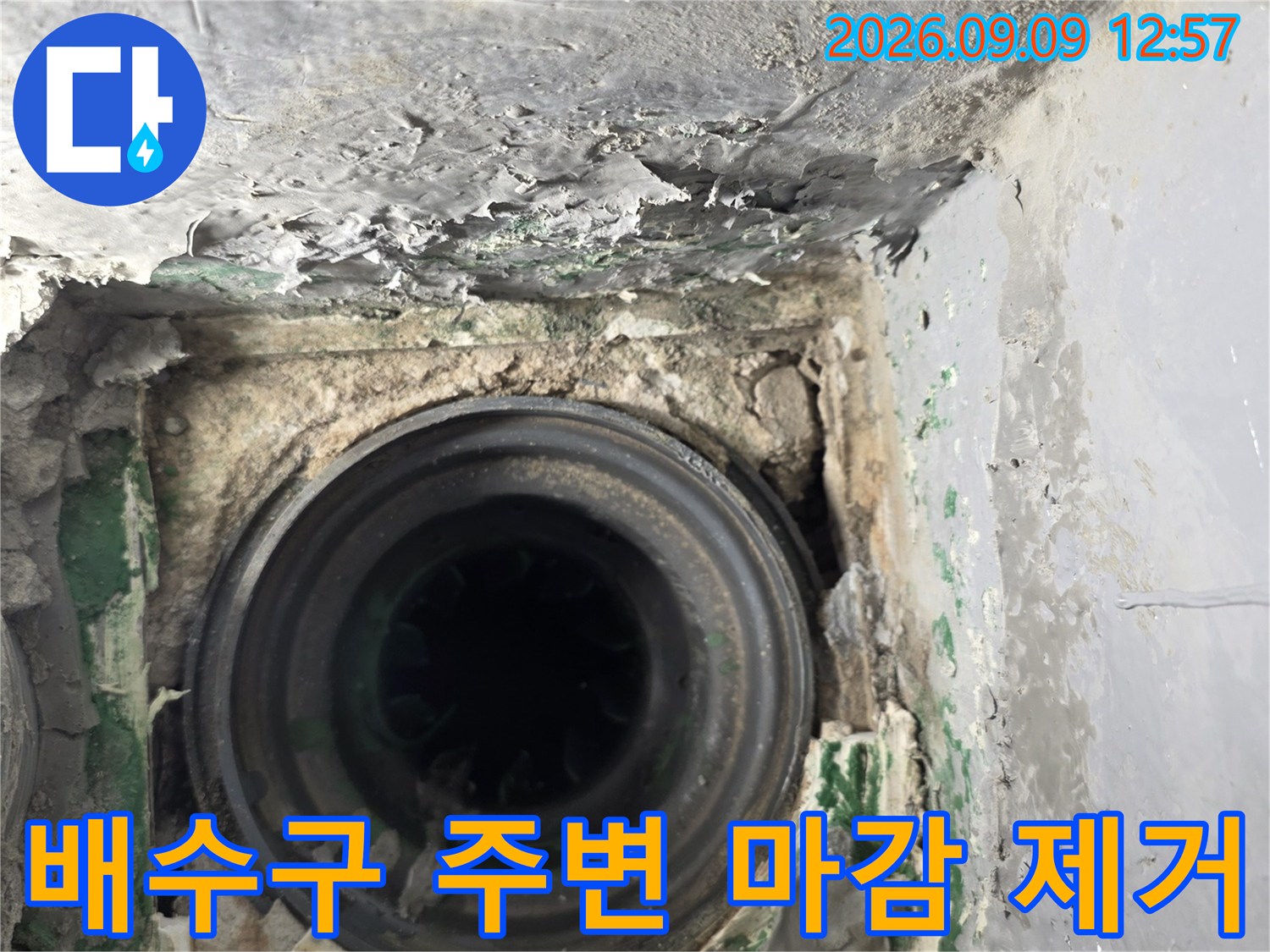 배수구 주변의 시멘트 마감재를 걷어낸 배관 노출 상태
