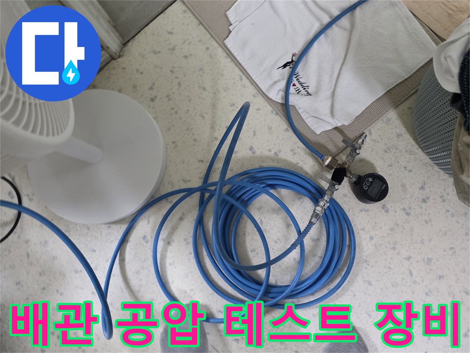배관 연결 부위에 설치된 압력 게이지와 파란색 호스