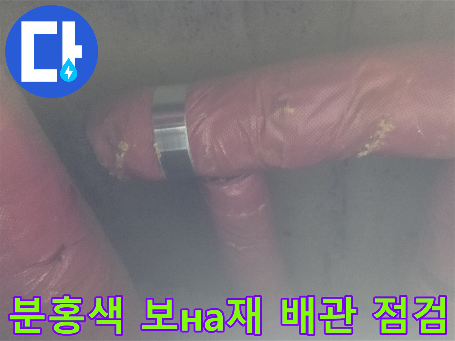 배관의 연결 부위와 분홍색 보온재를 면밀히 관찰하는 작업자 손길