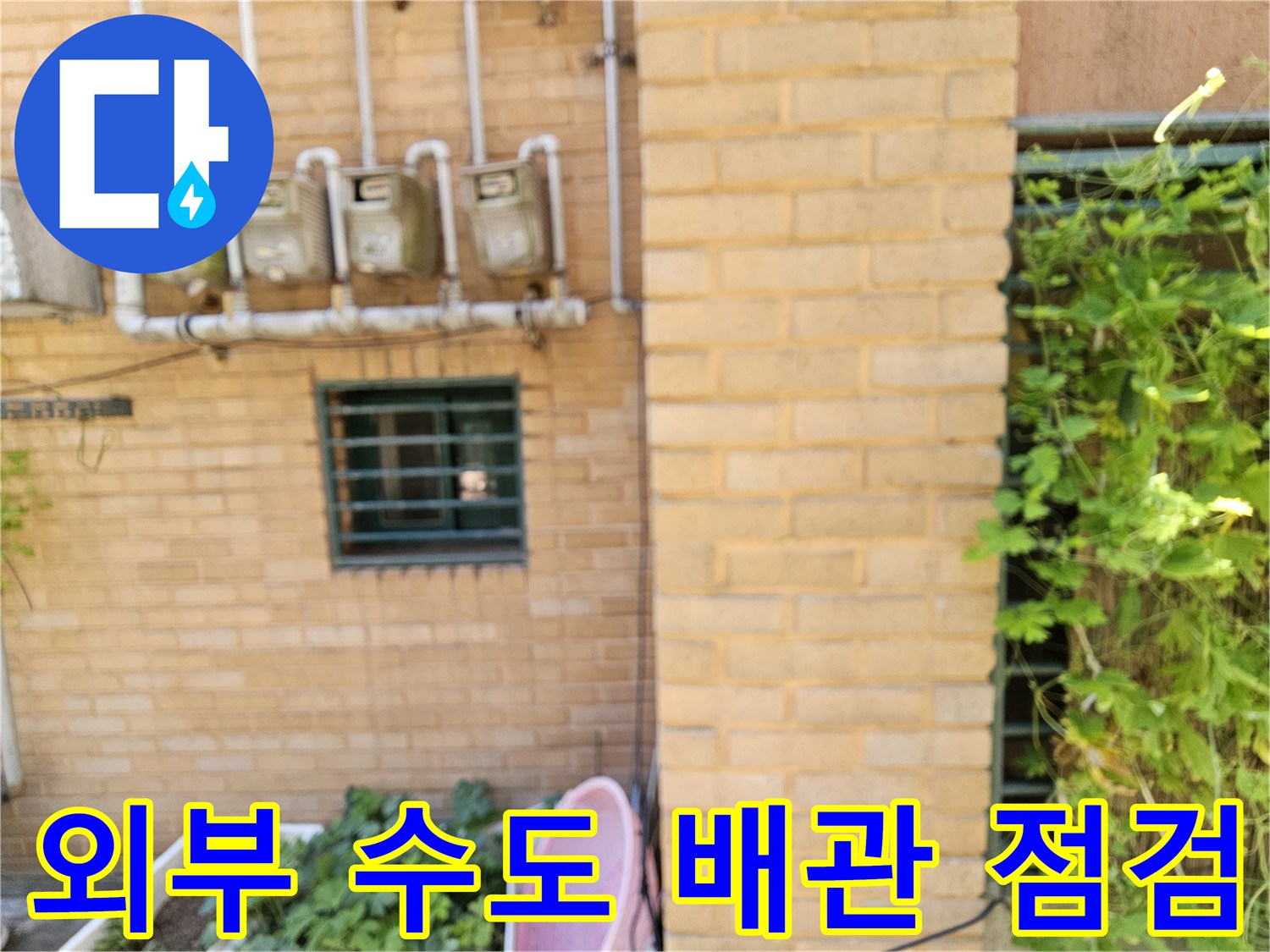 벽돌 외벽에 설치된 여러 개의 수도 계량기와 연결관