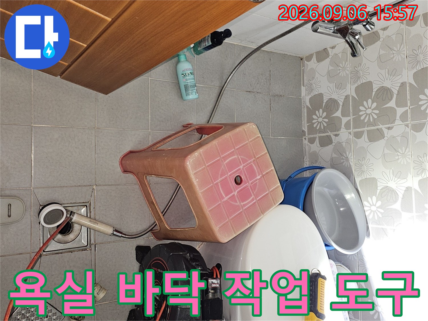 화장실 변기 옆에 놓인 압력계와 작업용 드릴 및 배관 점검 장비 세트