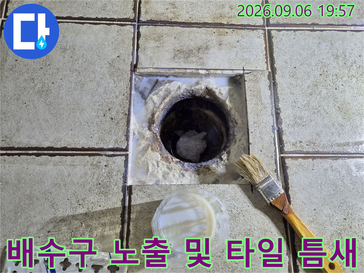 바닥 배수구 주변의 파헤쳐진 부위와 작업 도구 사진