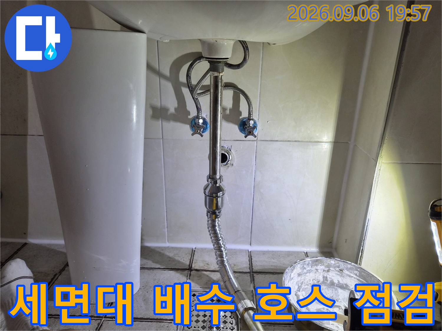 세면대 아래쪽 은색 자바라 호스와 급수 밸브 연결 부위 상세 사진