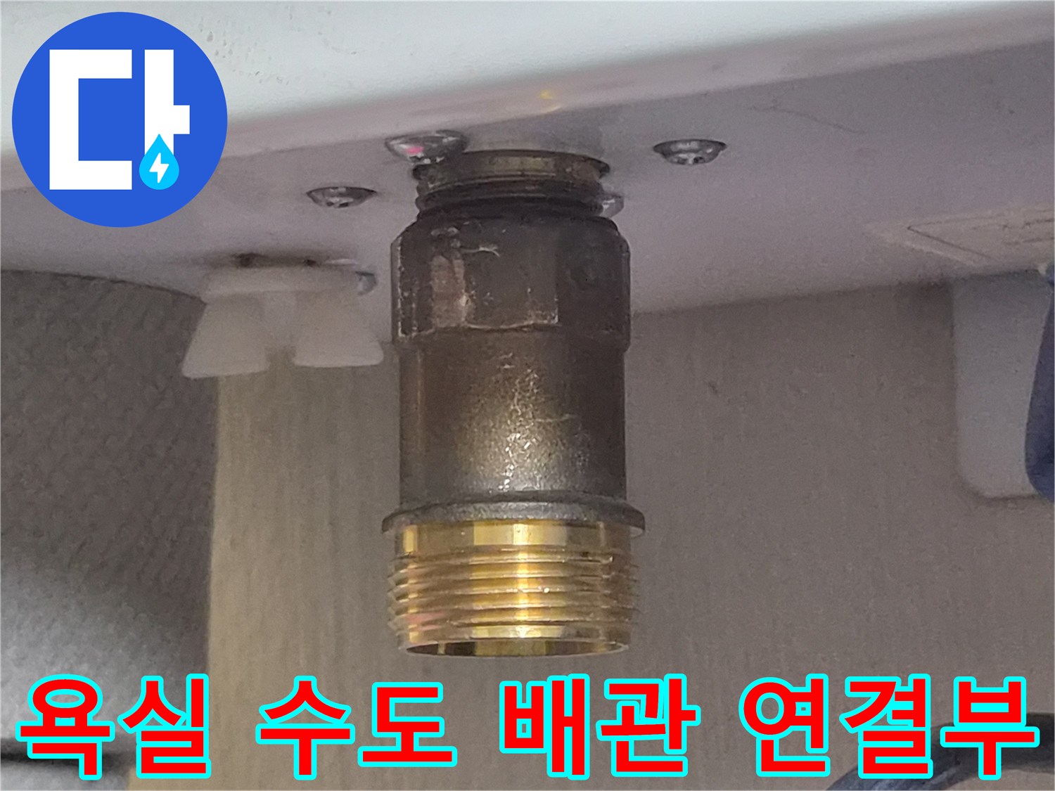 상단 어댑터와 하단 황동색 나사산 배관의 접합부