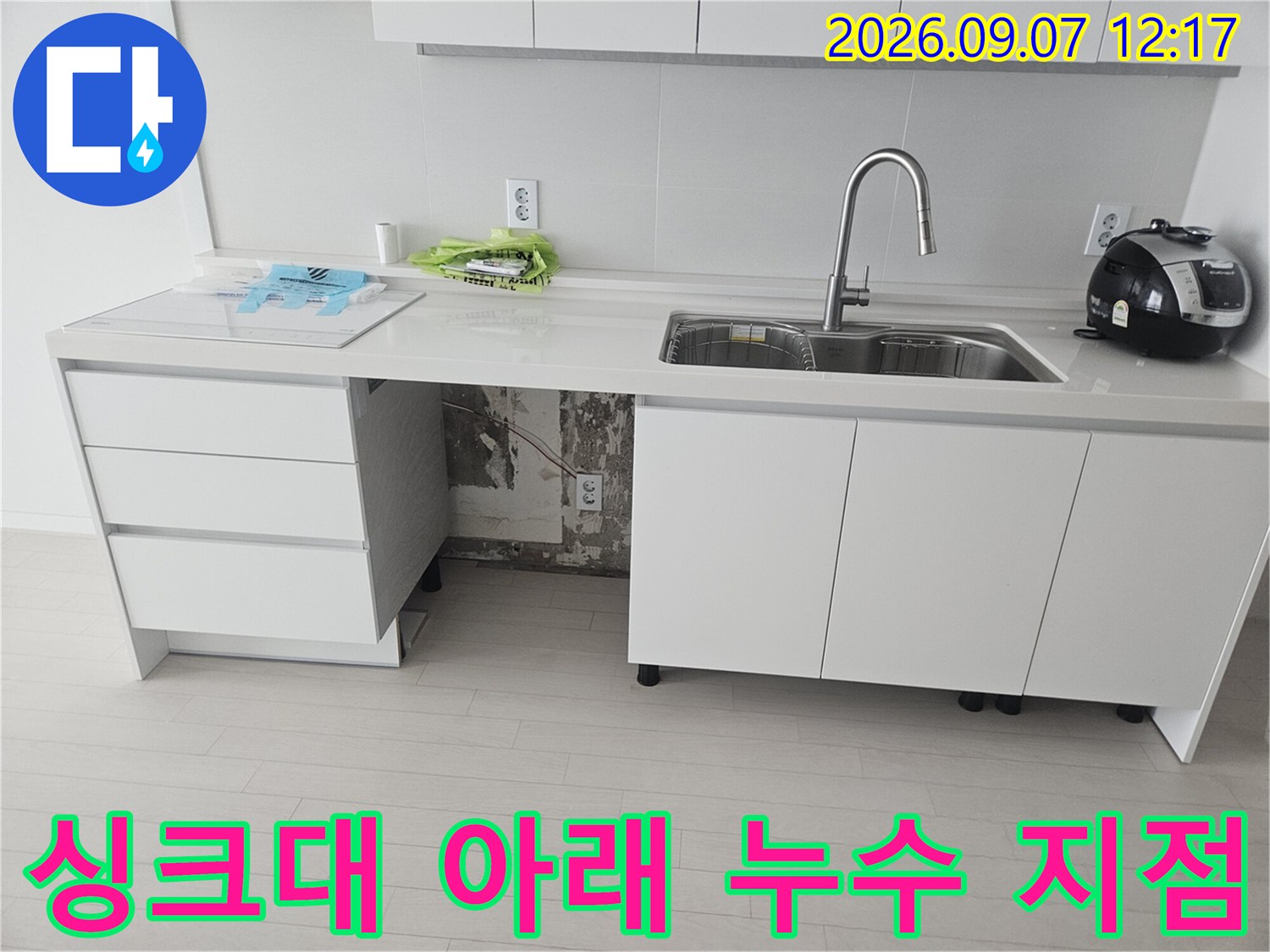 싱크대 하부 배관의 절단된 부위와 테이핑된 연결부를 보여줍니다.