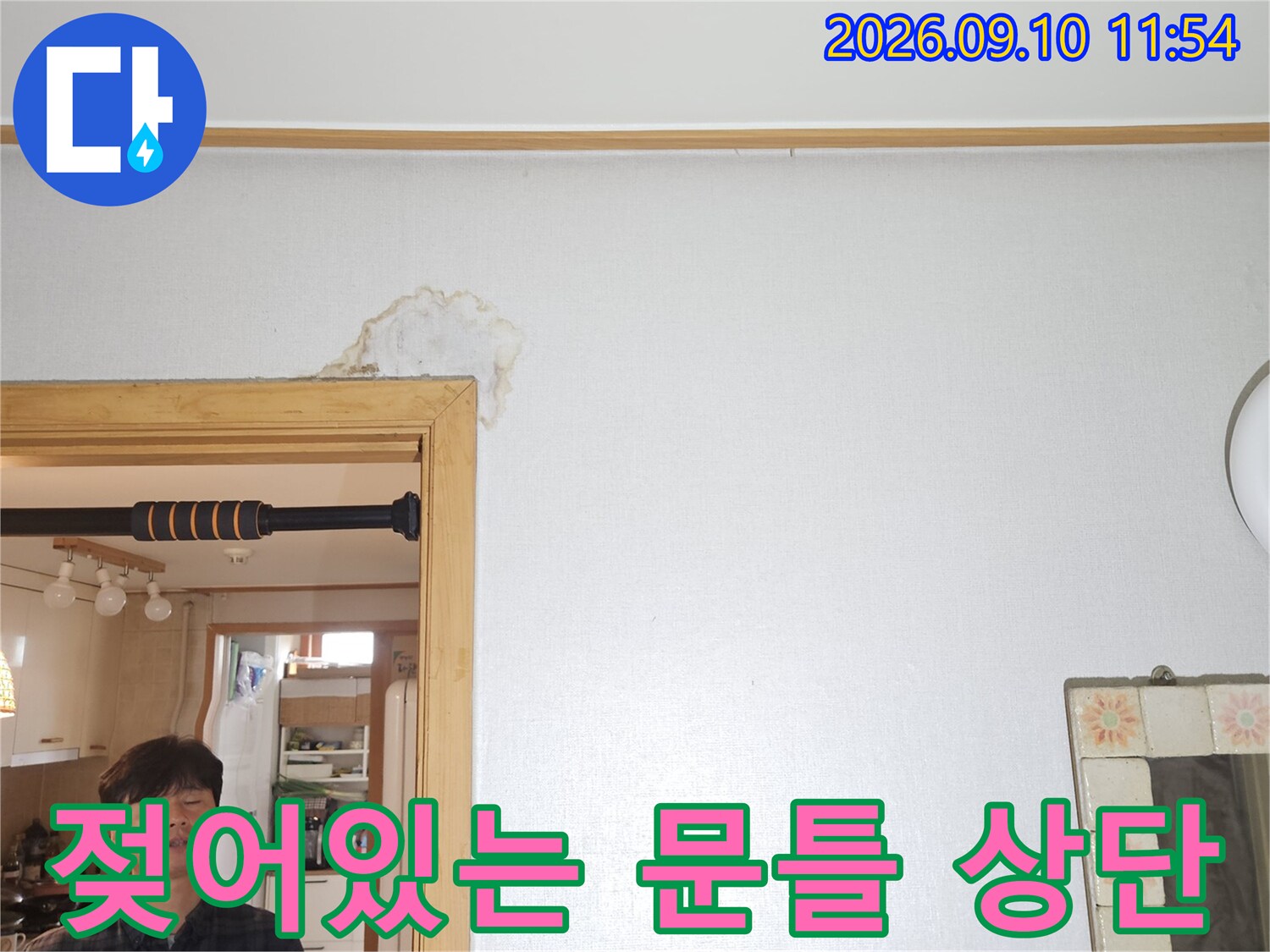 문틀 위쪽 벽면의 젖은 얼룩을 근접하여 촬영한 사진입니다.