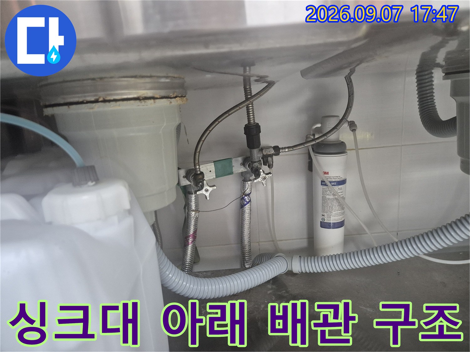 싱크대 하부의 직수 연결 앵글밸브와 분기 부속 상세 모습