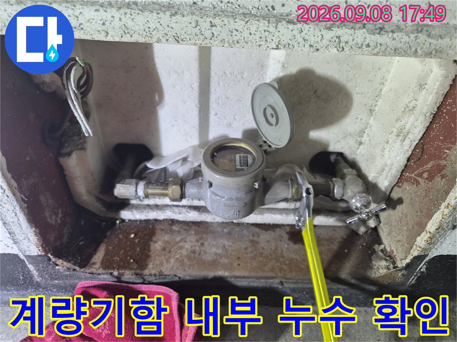 습기가 찬 수도 계량기 함 내부와 연결된 배관의 상태를 보여주는 사진입니다.
