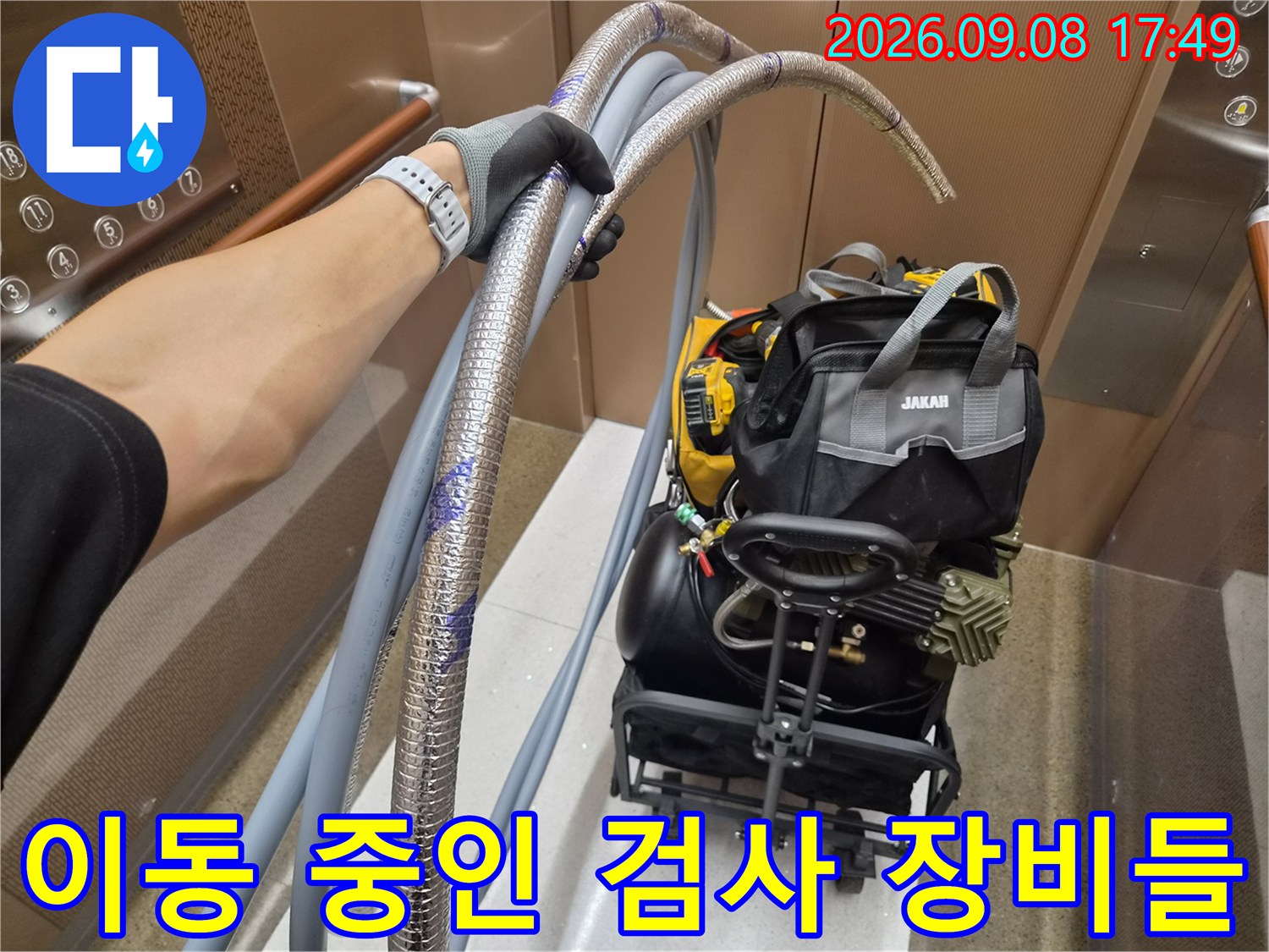 엘리베이터 안의 누수 탐지용 호스 뭉치와 기계 장비