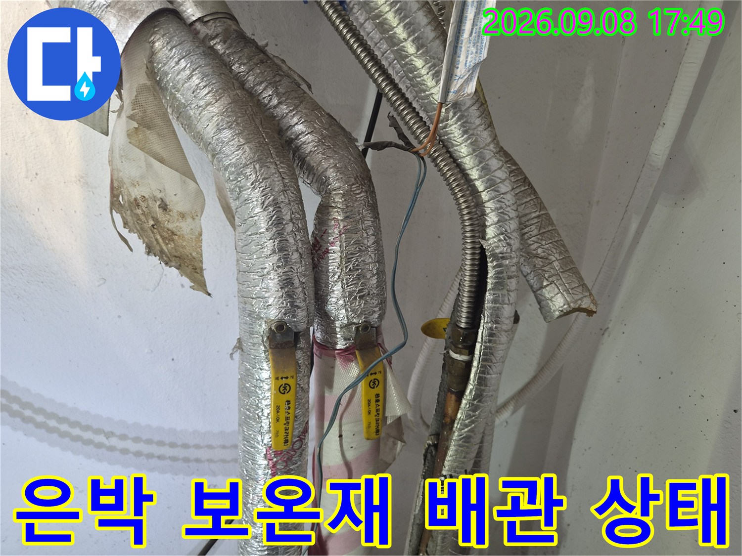 은박 보온재로 감싸진 누수 점검 중인 배관 부위입니다.