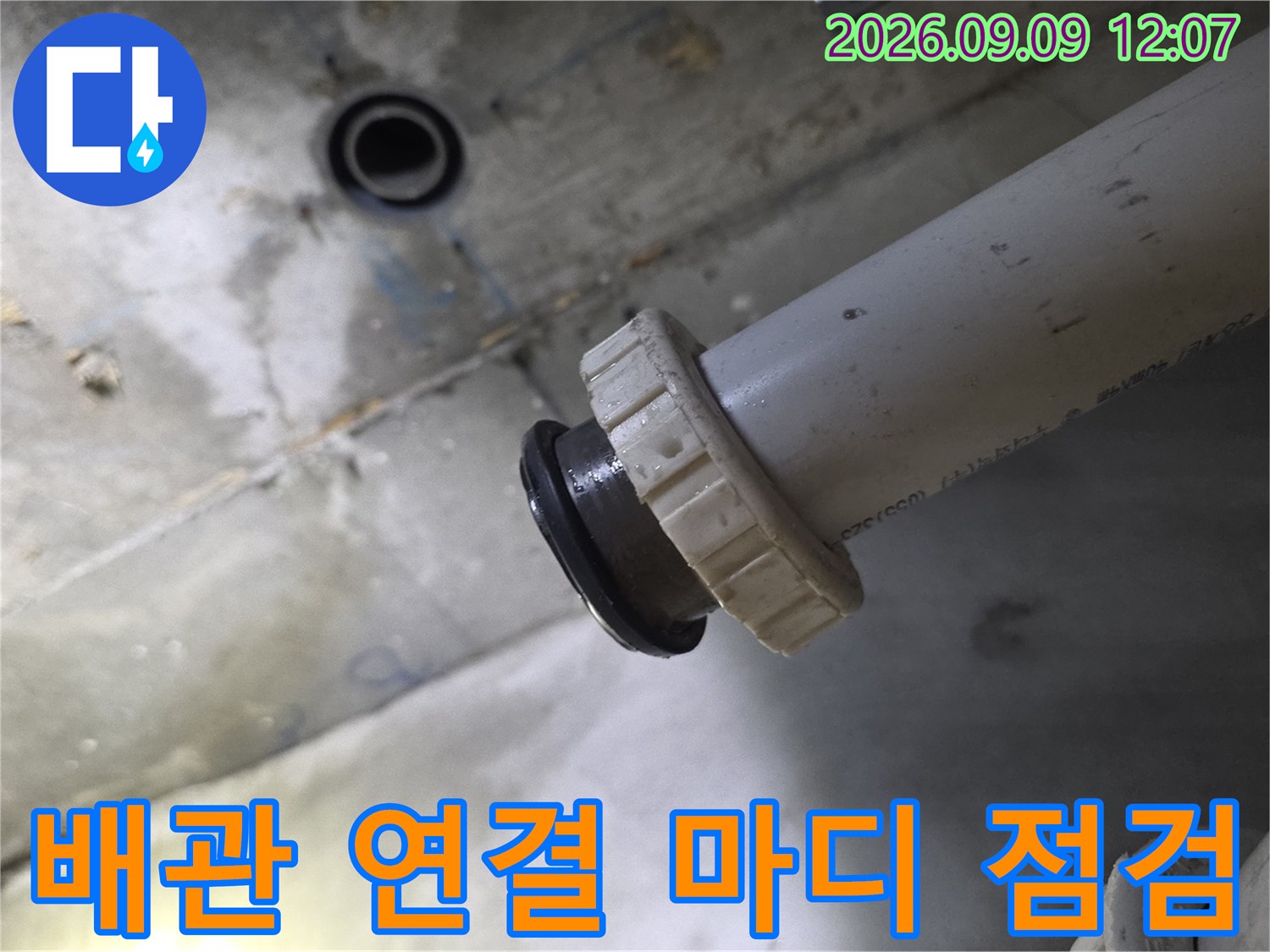 천장 내부 배관의 결합 부위와 고무 링을 근접하여 촬영한 모습입니다.
