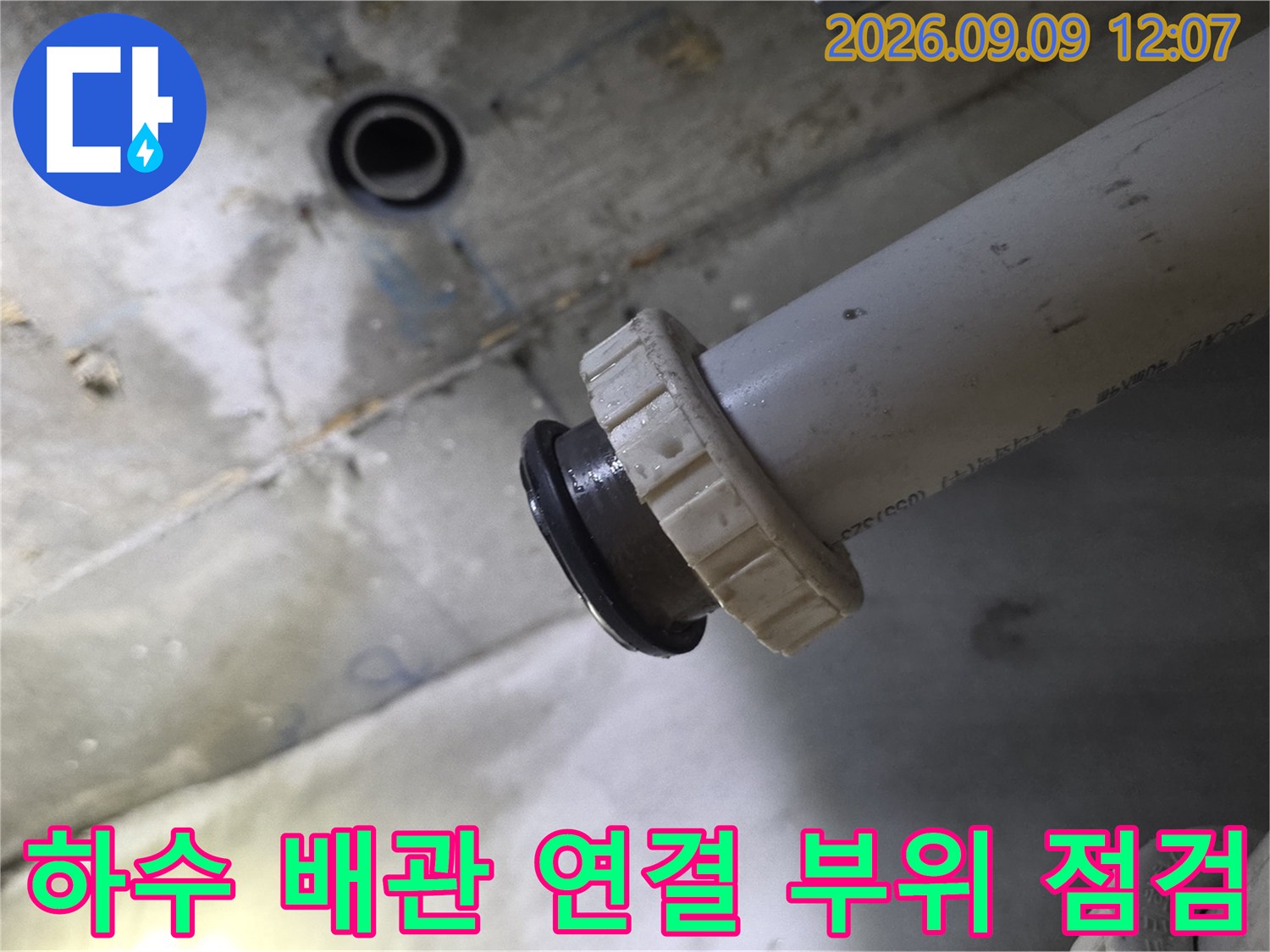 천장 내부로 노출된 하수 배관의 연결 상태를 촬영한 사진입니다.