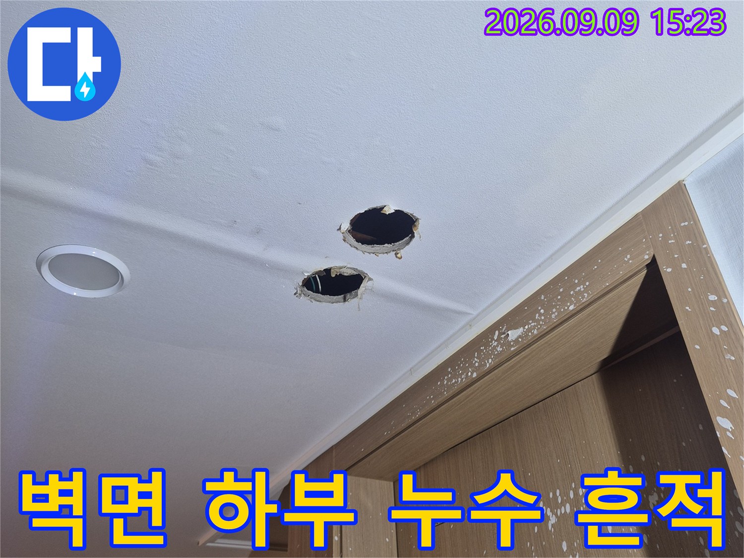 싱크대 아래쪽 벽면에 나타난 물샘 흔적과 확인용 타공 구멍