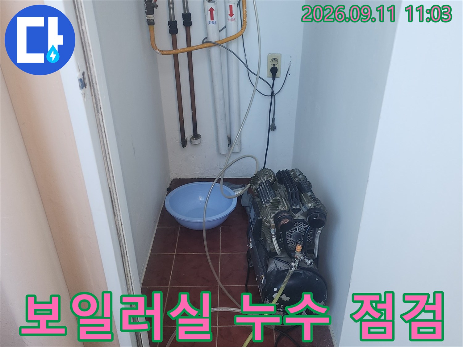 보일러 배관에 연결된 공기압 테스트용 호스와 장비입니다.