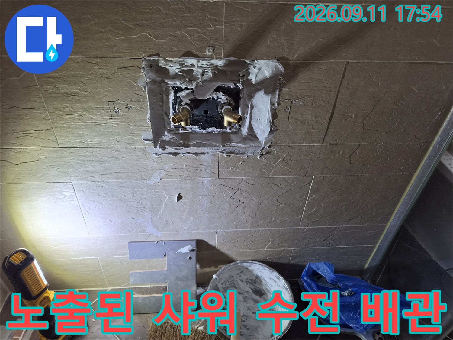 중구 황학동 현장-타일 제거 후 드러난 금속 배관과 주변의 시멘트 마감 상태입니다.