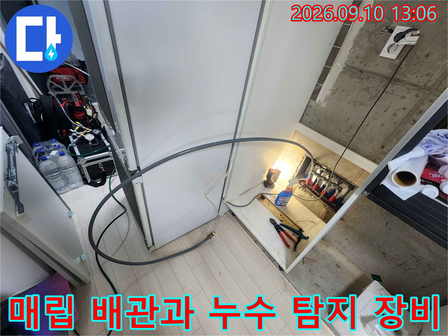 누수 지점을 찾기 위해 배치된 다양한 공구와 점검 중인 배관 라인입니다.