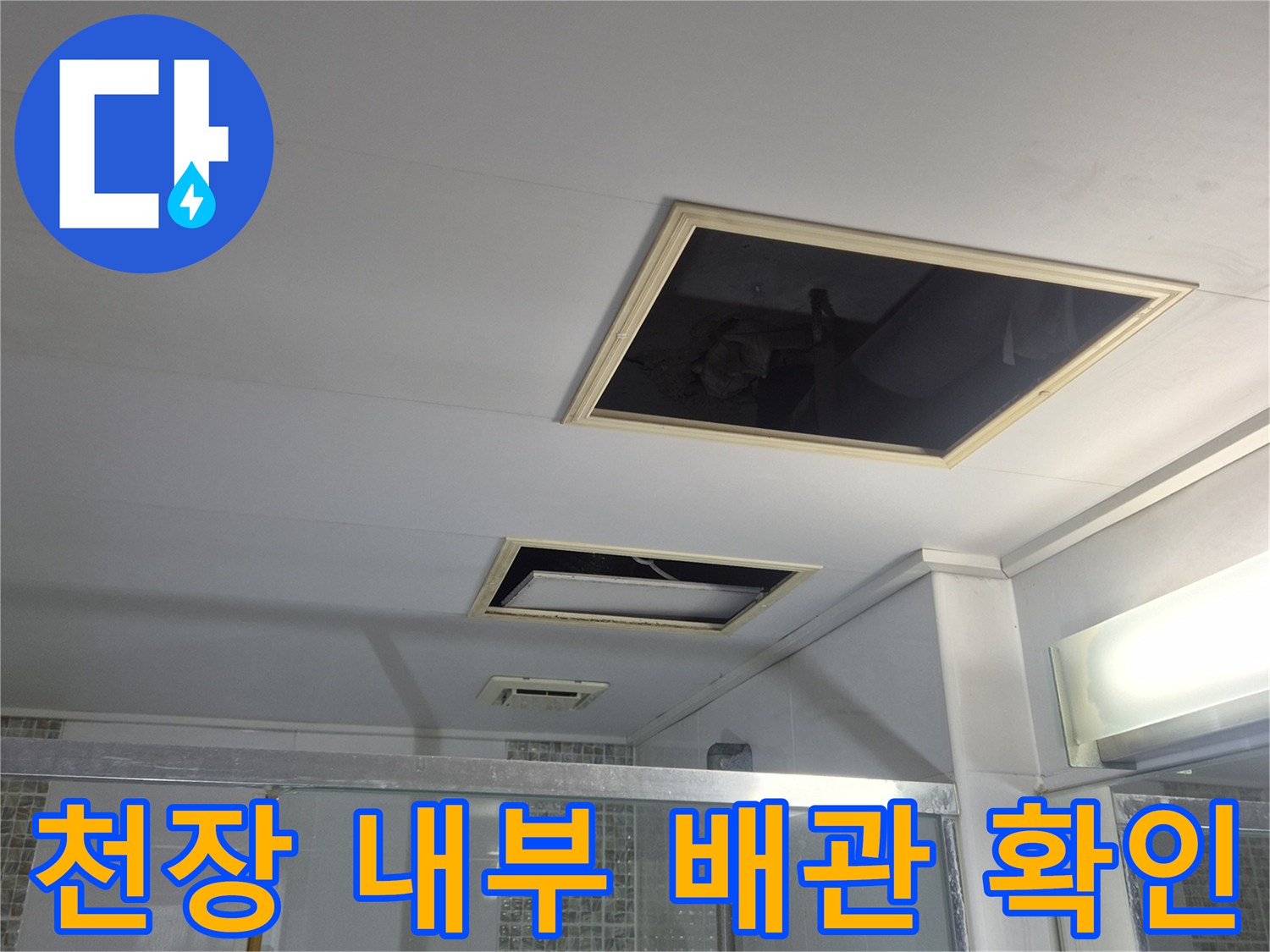 화장실 천장 점검구를 열어 내부를 점검하고 있습니다.