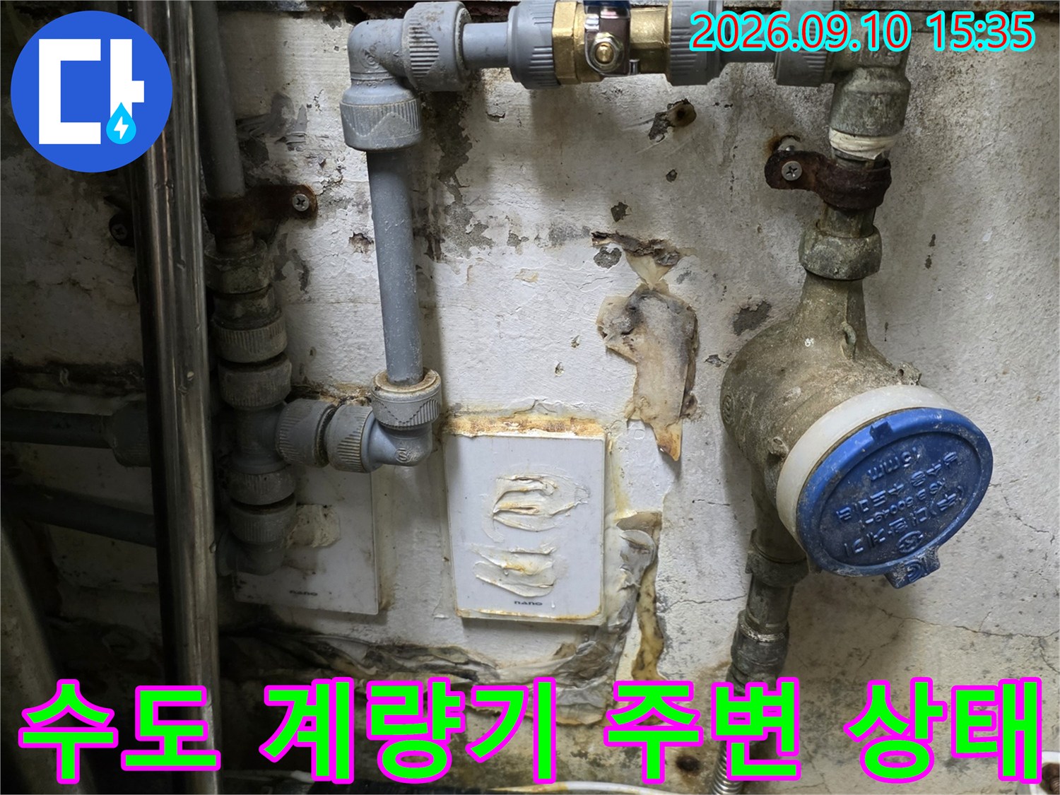 식당 주방 벽면에 설치된 수도 계량기와 연결된 배관의 모습