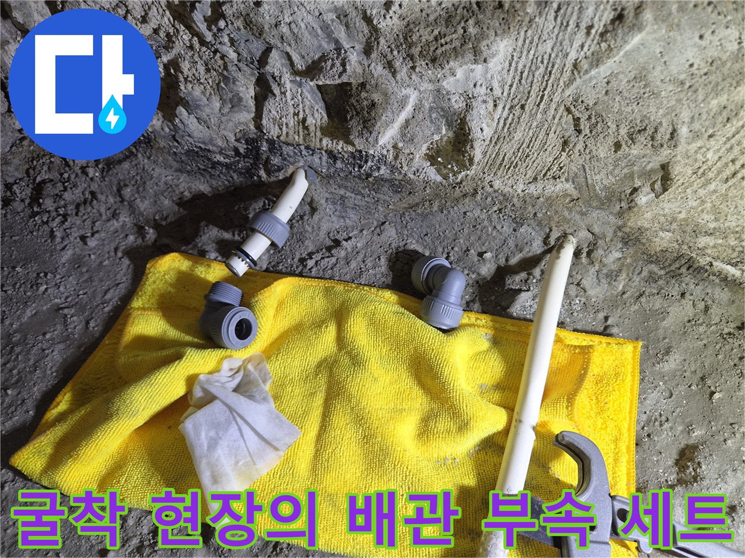 노란 천 위에 놓인 배관 연결 자재와 작업 도구
