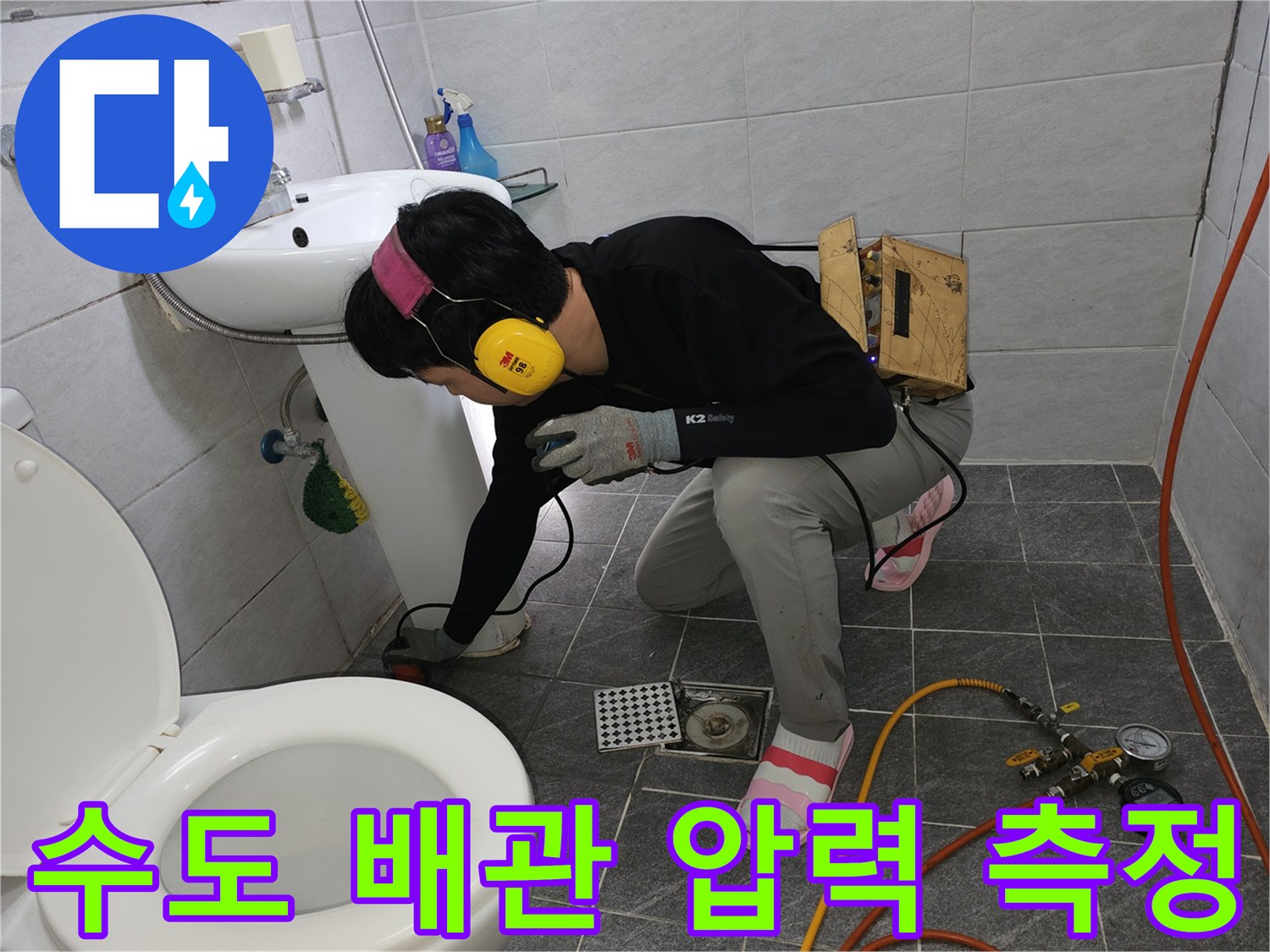 세면대 하부 배관에 압력계를 연결하여 수압 손실을 체크하는 작업 모습