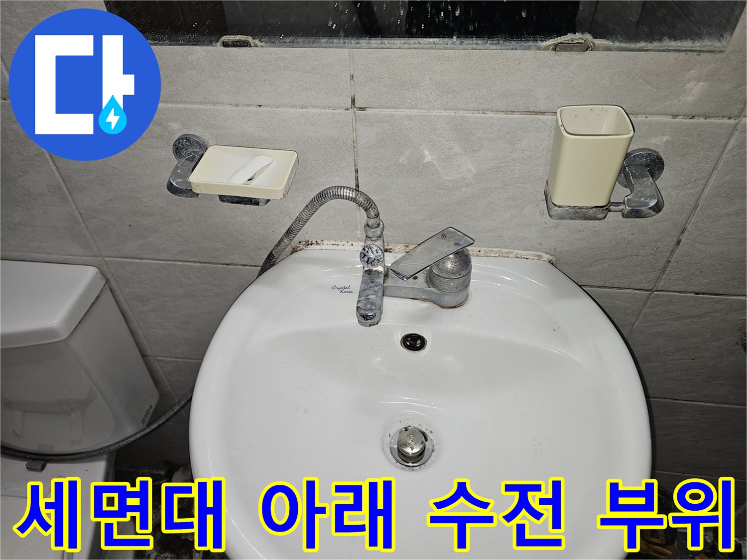 화장실 세면대 수전과 연결 호스의 근접 촬영입니다.
