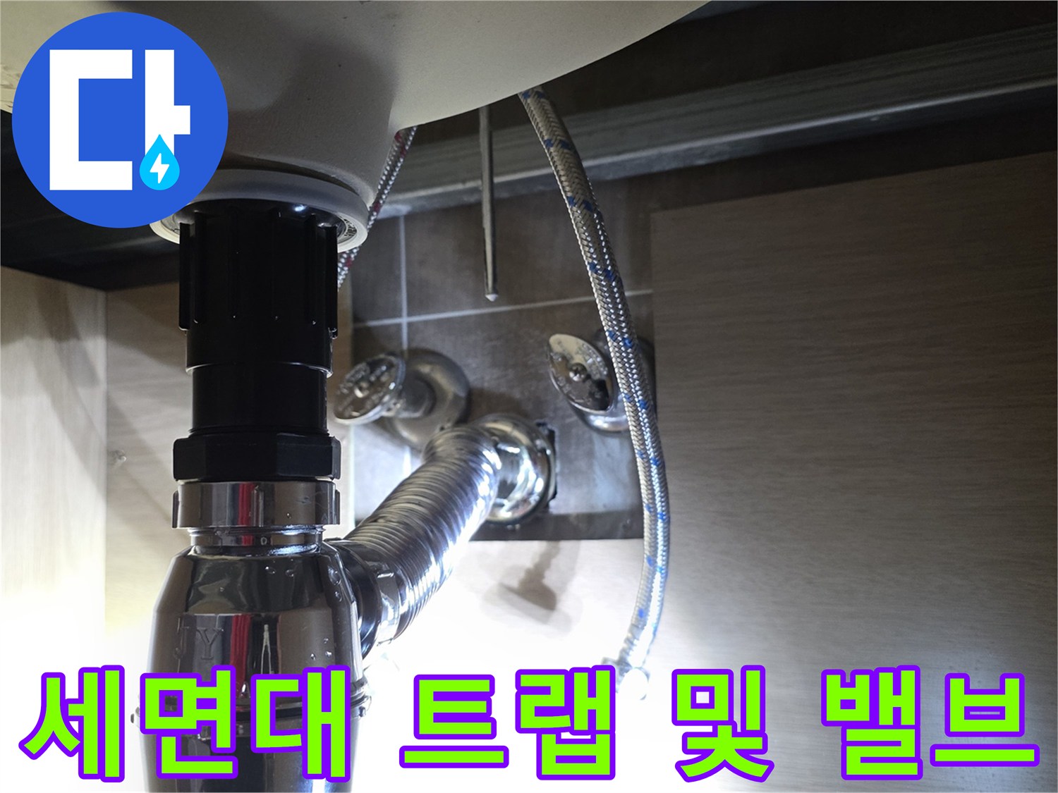 세면대 하단 은색 배관과 연결된 급수 호스의 모습